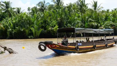Ben Tre Tour | The Secret of The Coconuts “Capital” - An experienced local boat captain skillfully navigating the waterways during a Mekong Smile tour in Ben Tre - 18714