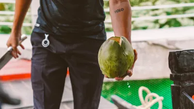 Ben Tre Tour | The Secret of The Coconuts “Capital” - A friendly Mekong Smile tour guide carefully chopping a fresh coconut for a guest in Ben Tre - 18716